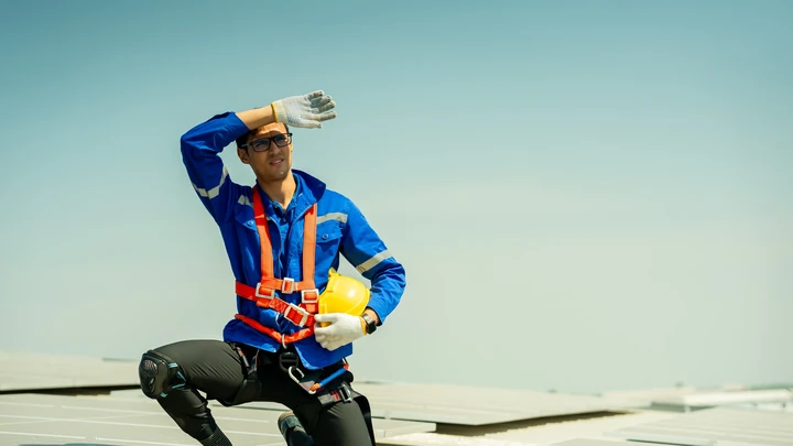 Trabajador expuesto al sol protegiéndose del calor durante una jornada al aire libre, representando la prevención ante temperaturas extremas.