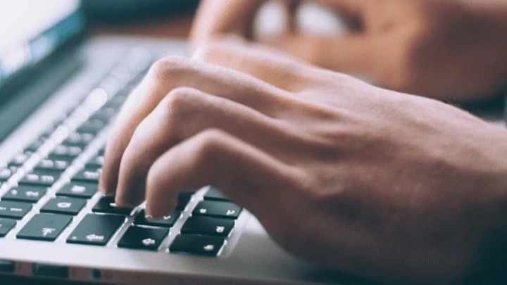 Persona escribiendo en un portátil, representando los retos y oportunidades de la transformación digital en asesorías.