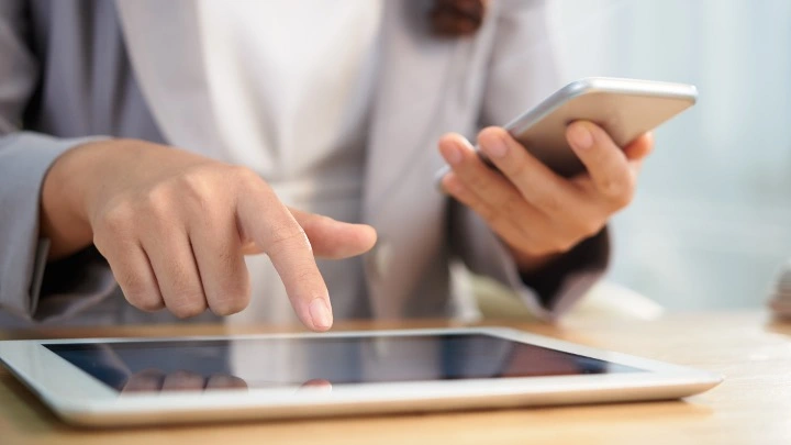 Profesional gestionando trámites desde dispositivos digitales, simbolizando la digitalización y automatización de asesorías y despachos profesionales.