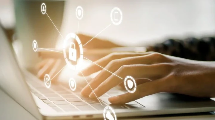 Manos trabajando en un portátil con iconos digitales, representando la renovación de certificados digitales.