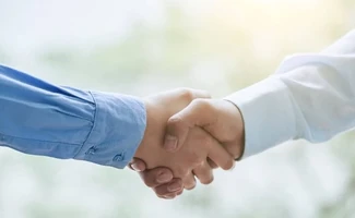 Dos personas estrechándose la mano, simbolizando confianza, seguridad y buena gestión profesional en una comunidad de propietarios.