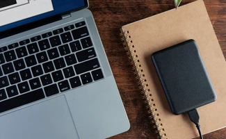 Ordenador portátil y teléfono móvil sobre una mesa, representando la gestión de certificados digitales de pymes y autónomos.