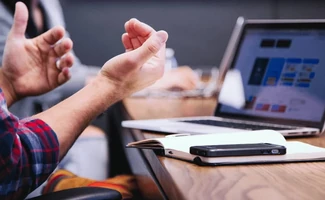 Personas reunidas con un portátil abierto, representando la tramitación online con la Administración Pública.